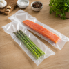 Gladde transparante vacuümzakken in gebruik voor het luchtdicht verpakken van een verse zalmfilet en groene asperges. De heldere, gladde folie sluit strak aan om de producten en zorgt voor een professionele, hygiënische verpakking die de versheid, smaak e