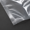 Close-up detailfoto van een transparante krimpzak met bodemseal, waarbij de sterke gesealde hoek, glanzende transparante folie en hoogwaardige afwerking van het verpakkingsmateriaal zichtbaar zijn.
