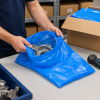 Blauwe HDPE zak 20 my formaat 400 × 600 mm in gebruik voor het verpakken van metalen onderdelen, ideaal voor stofvrije opslag en veilig transport in een magazijn- of productieomgeving.