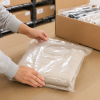 Transparante LDPE zak van 600 × 800 mm in gebruik voor het verpakken van een opgevouwen trui. De gladde, heldere folie beschermt het kledingstuk tegen stof, vuil en vocht tijdens opslag, transport en verzending.