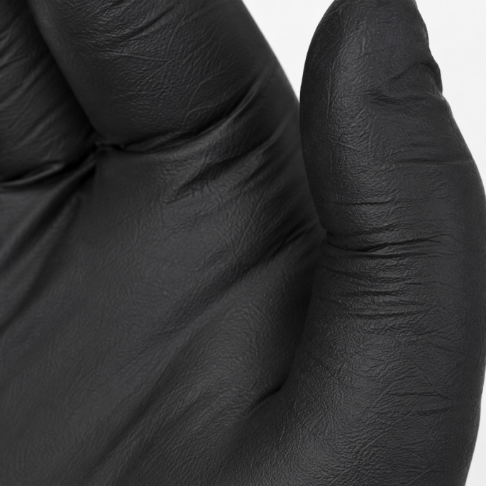 Extreme close-up van een zwarte extra dikke nitril handschoen maat M, met focus op de fijne textuur, materiaaldikte en beschermende afwerking.
