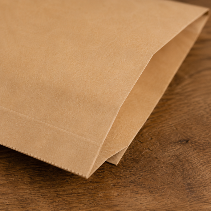 Detailfoto van een bruin FSC papieren hamburgerzakje met zicht op de gevouwen hoek en natuurlijke kraftpapierstructuur. De close-up toont de hoogwaardige afwerking en stevige kwaliteit van het zakje.