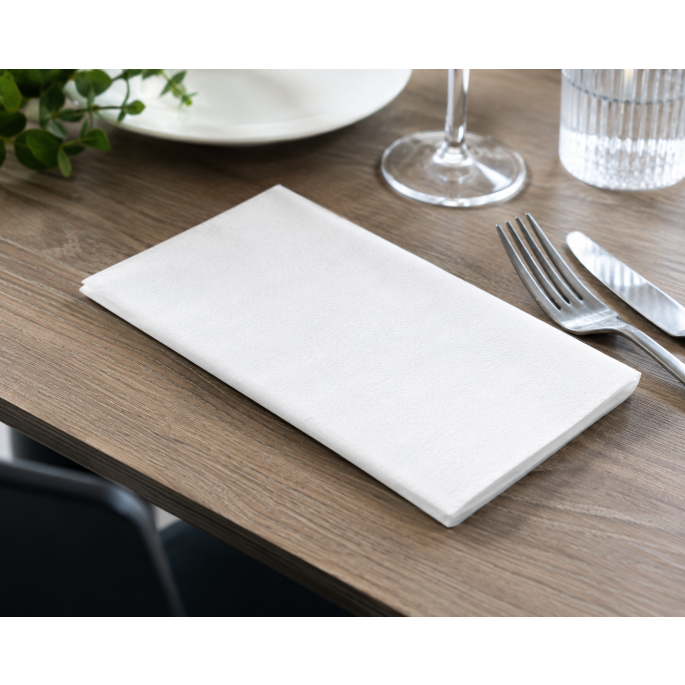 Hoogwitte 1-laags servet 1/4 vouw in gebruik op een professioneel gedekte restauranttafel, geschikt voor horeca, catering en tafelaankleding.