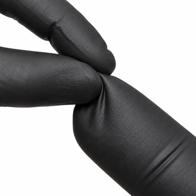 Close-up van een zwarte nitril handschoen die wordt uitgerekt, wat de flexibiliteit en elasticiteit van het materiaal laat zien.